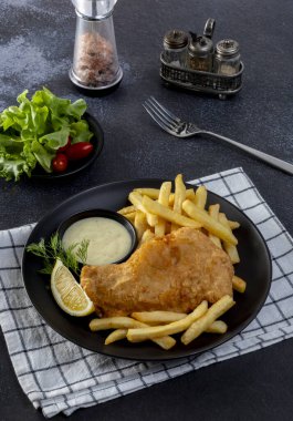 Balık ve patates kızartması: Klasik haşlanmış balık, altın patates kızartması ve tartar sosuyla servis edilir..