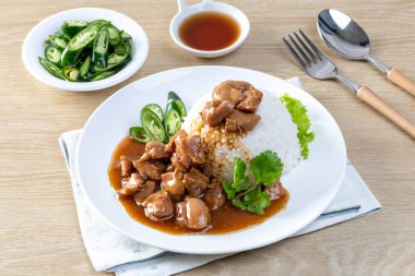 Kahverengi soslu tavuk mu yoksa ahşap bir masada pirinç soslu sos mu?