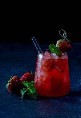 Taze yaz çileği, buzlu içecek, siyah taşta servis edilir.