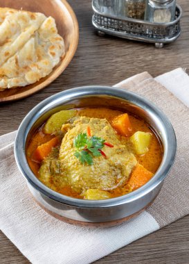 Tay sarısı körili tavuk ve paslanmaz çelik kasede roti.