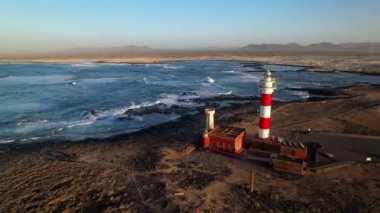 Gün batımında deniz feneri olan deniz manzarası. Hava aracı görüntüsü, Fuerteventura. Kanarya adası, El Cotilio köyü. El Toston Deniz Feneri