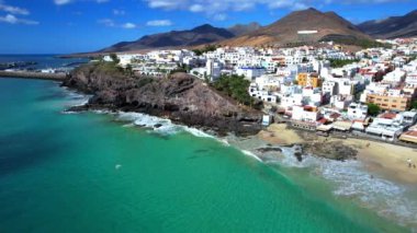 Fuerteventura Kanarya Adaları. Morro Jable kasabasının ve güzel kumlu kumsalın insansız hava aracı videosu. Popüler turizm beldesi
