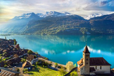 beautiful idylic nature scenery of lake Brienz with turquoise waters. Switzerland, Bern canton. Aerial view with little church in the morning light clipart