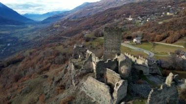  Medieval impressive castle Cly surrouded by Alps mountains in Valle d'aosta, aerial drone view