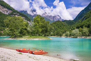 İtalya 'nın Trentino bölgesinde, Alpler dağlarıyla çevrili muhteşem turkuaz göl Tenno. Küçük ada ve kanoyla panoramik manzara