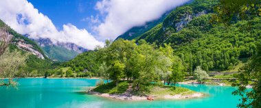 İtalya 'nın Trentino bölgesinde, Alpler dağlarıyla çevrili muhteşem turkuaz göl Tenno. Küçük ada ve kanoyla panoramik manzara