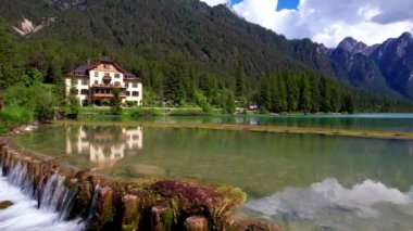 Kuzey İtalya 'nın en güzel ve manzaralı gölleri. Val Pusteria, Güney Tyrol 'daki Lago di Dobbiaco. Trentino-Alto Adige. 4K içinde hava aracı uçuş videosu