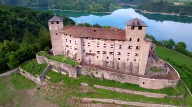 Kuzey İtalya 'nın en ünlü ve en güzel ortaçağ kaleleri. Trentino, Trento 'da manzaralı Cles kaleleri. Santa Giustina Gölü. Val di Non Elma Vadisi. hava aracı görünümü