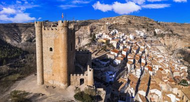 İspanya, Alcala de Jucar - kayalıklarda bulunan ortaçağ köyü. Kaleyle birlikte yüksek açılı hava aracı görüntüsü. Castilla-la Mancha Bölgesi