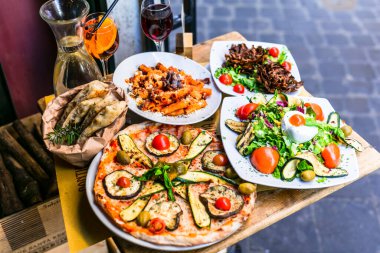 İtalya 'da seyahat, İtalyan kültürünün bir parçası - sağlıklı Akdeniz italyan yemekleri. Tipik makarna, pizza ve salata çeşitleri olan Roma sokak restoranları.