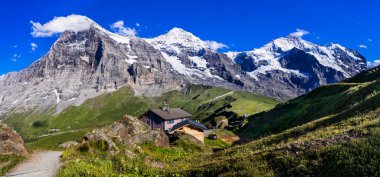 amazing Swiss nature . Kleine Scheidegg mountain pass  famous for hiking in Bernese Alps. view of highest peaks Eiger , Monc and Jungfrau, Switzerland travel clipart