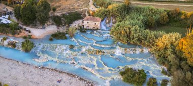 Most famous natural thermal hot spings pools in Tuscany - scenic Terme di Mulino vecchio ( Thermals of Old Windmill) in Grosseto province.  high angle drone view clipart