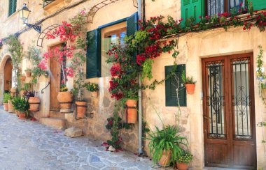 Mallorca (Mayorka) adası - geleneksel Valldemossa köyü çiçek desenli sokak dekorasyonuyla. Popüler turist eğlencesi. İspanya, Balear Adaları