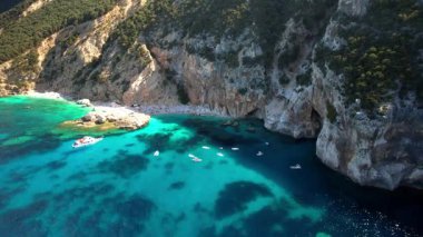 Sardegna adasının (İtalya) en iyi ve en güzel plajları - Orosei körfezinde etkileyici Cala Mariolu. Beyaz kumlu sahil ve turkuaz deniz manzaralı hava aracı videosu.