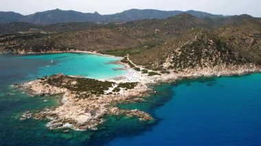 Sardegna (Sardinya) İtalya. Güney bölgesinin en güzel sahili. Turkuaz deniz ve beyaz kumlu plajlı güzel Punta Molentis. Hava aracı 4k hd video