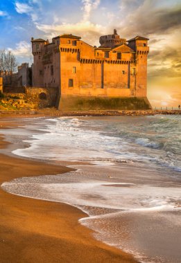 İtalya 'nın büyük ortaçağ kaleleri. Gün batımında Santa Severa sahilindeki Castello' yu güzelleştir. Lazio bölgesi. dramatik deniz sahili manzarası