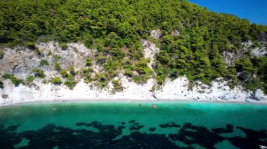 Yunanistan 'ın en iyi plajları. Sporade. Yeşil tepelerle çevrili turkuaz kristal deniz ile Hovolos plajı (Neo klima köyü yakınlarında). Hava Aracı 4k hd video