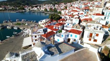Geleneksel Yunan adaları - Sporade 'de otantik the Sporelos. Whitewashed evlerin ve Chora 'nın eski limanının 4k hava aracı videosu. Yunanistan seyahati ve manzaralı yerler