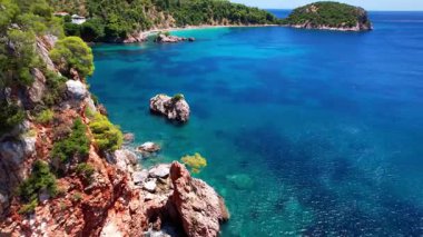 Yunanistan 'ın en iyi plajları. Yeşil tepelerle çevrili turkuaz kristal denizi olan Stafilos (Stafilos) adası. - Evet. aeriah yüksek açılı drone 4k HD video