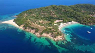 Yunanistan, Skiathos Adası 'nın (Sporades) en güzel plaj merkezleri - beyaz kumlu plajlarıyla büyüleyici ada Tsouguria. Yüksek açılı insansız hava aracı 4k hd video