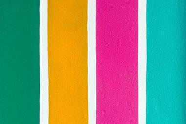 Beton duvarda çok renkli çizgili desen var. Duvarın çimento yüzeyine renkli boyanmış. Gökkuşağı renginde grafiti. Duvarlarla dolu bir renk. Renkli çit, çok renkli beton çit..