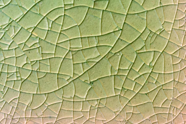 Close up to background and texture of stretch marks cracked on emerald green glazed tile. Scratches background. Vintage scratched grunge tile broken screen texture. Scratched glass surface wallpaper.