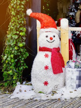 Güzel dekoratif yapay kardan adam dekorasyonu küçük bir yerleşim yerinin girişinde. Noel tatilinde halk parkının önünde duran kardan adam. Noel ve Yeni Yıl Konsepti.