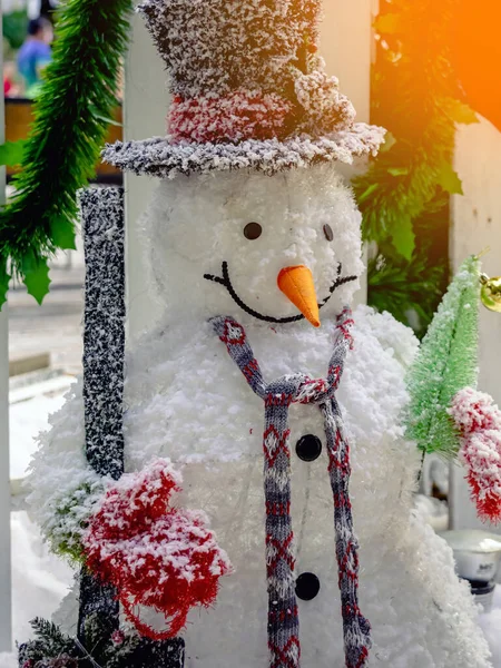 Beautiful decorative artificial snowman decoration at the entrance to a small housing community. Snowman standing in front of the public park on the Christmas holiday. Christmas and New Year Concept.