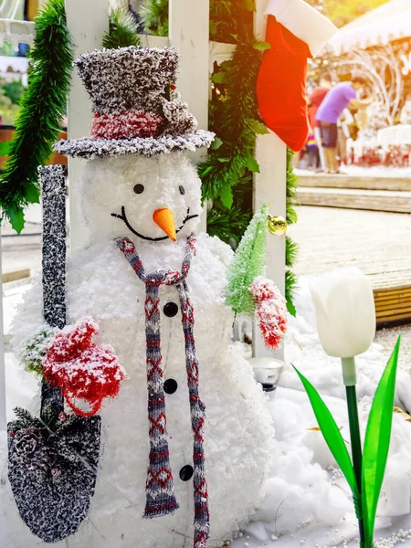 Beautiful decorative artificial snowman decoration at the entrance to a small housing community. Snowman standing in front of the public park on the Christmas holiday. Christmas and New Year Concept.
