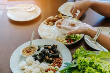 Enjoy eat with Vietnamese Meatball Wraps (Nam-Neung), Pork Sausage wraps with fresh vegetables in rice paper, generous platter eat with sweet sauce. Vietnamese Pork Sausage and salad. Selective focus.