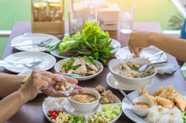 Enjoy eat with Vietnamese Meatball Wraps (Nam-Neung), Pork Sausage wraps with fresh vegetables in rice paper, generous platter eat with sweet sauce. Vietnamese Pork Sausage and salad. Selective focus.