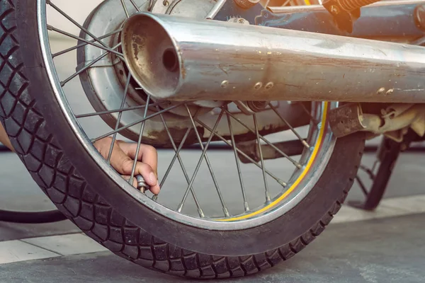 人手用空压机检查充气器的压力 并用摩托车给轮胎充气 男子检查空气压力 并从自动进气口充填摩托车车轮上的轮胎压力 — 图库照片