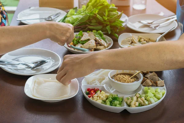 Enjoy eat with Vietnamese Meatball Wraps (Nam-Neung), Pork Sausage wraps with fresh vegetables in rice paper, generous platter eat with sweet sauce. Vietnamese Pork Sausage and salad. Selective focus.