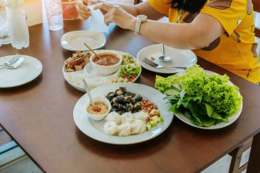 Enjoy eat with Vietnamese Meatball Wraps (Nam-Neung), Pork Sausage wraps with fresh vegetables in rice paper, generous platter eat with sweet sauce. Vietnamese Pork Sausage and salad. Selective focus.