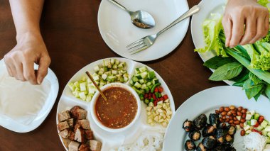 Close up to dipping sauce for Vietnamese Meatball Wraps (Nam-Neung), Pork Sausage wraps with fresh vegetables in rice paper, generous platter eat with sweet sauce. Vietnamese Pork Sausage and salad.