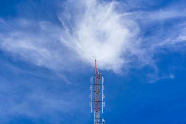 Telecommunication radio wave signal tower red and white with cloudy. Steel truss of transmission signal antenna with blue sky. Telecommunication tower, Global connection and internet network concept.