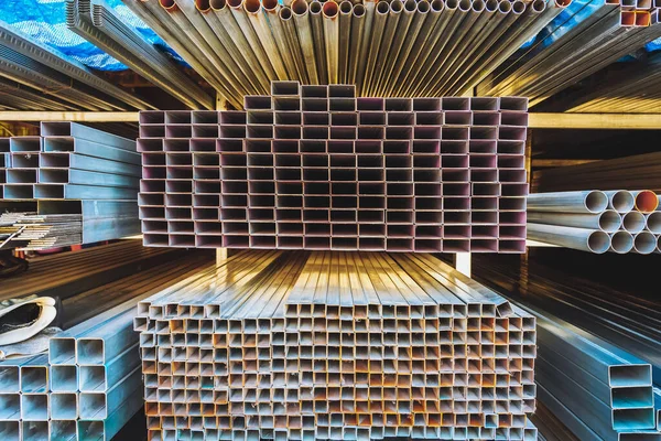 Various shape of many different steel bars and tubes for sale on storage shelf. Warehouse shop for sale of metal structures, Profile of iron pipes, corners, channel bars, I-beams, industry steel bar.