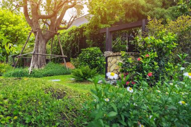 Taş ve tekerlek makara ile yapılmış güzel artezyen metal kova ve halatla huzurlu bahçe atmosferinde. Kırsal alandaki Retro Stone Kuyusu. Antika eşyalarla güzel bir bahçe dekorasyonu..