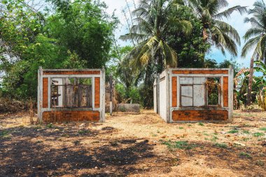 Kırık kapıları ve pencereleri olan terk edilmiş eski bir tuğla evin dışında. Tamamlanmamış ve terk edilmiş bir ev. Banliyöde inşaat halindeki tek aile evinin beton dış cephesi.
