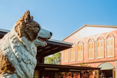 PHITSANULOK - THAILAND, 11 Aralık 2020: Bang Kaeo türünün beyaz kahverengi köpeğinin güzel bir heykeli Tayland 'da PTT benzin istasyonundaki Amazon kahve dükkanının önündeki Phitsanulok turizminin sembolüdür..