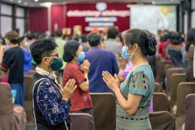 KANCHANABURI -THAILAND, 12 Eylül 2020: Tanımlanamayan yaşlı kadınlar yüz maskesi egzersizi giyerler ve Mittapan Hotel 'deki konser salonunda ritmik hareketler yaparlar. Faaliyetler İlişkiler Konferansı.
