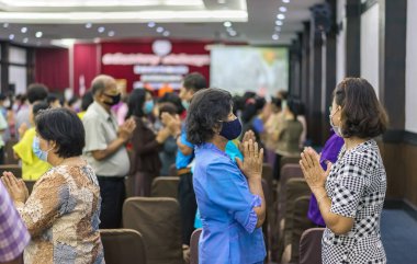 KANCHANABURI -THAILAND, 12 Eylül 2020: Tanımlanamayan yaşlı kadınlar yüz maskesi egzersizi giyerler ve Mittapan Hotel 'deki konser salonunda ritmik hareketler yaparlar. Faaliyetler İlişkiler Konferansı.