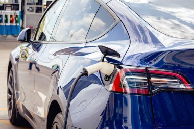 Elektrikli arabaları şarj ederken kablolu EV 'yi kabloya bağlamak. Yeşil enerji ve ekolojik güç kavramında elektrikli araba şarj istasyonu. Teknoloji elektrikli araç kavramı