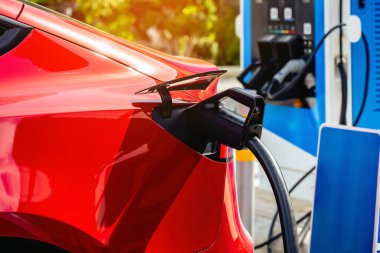 Elektrikli arabaları şarj ederken kablolu EV 'yi kabloya bağlamak. Yeşil enerji ve ekolojik güç kavramında elektrikli araba şarj istasyonu. Teknoloji elektrikli araç kavramı