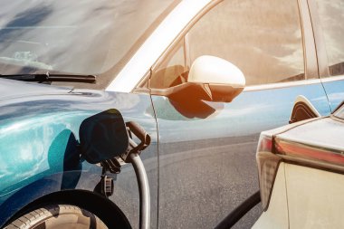Elektrikli arabaları şarj ederken kablolu EV 'yi kabloya bağlamak. Yeşil enerji ve ekolojik güç kavramında elektrikli araba şarj istasyonu. Teknoloji elektrikli araç kavramı