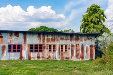 Eski çinko duvarlı ön cephe evi. Güzel bir galvanizli çarşaf evin dış yüzünü güzelleştirir. Ev duvarı yapmak için malzeme içeren paslı galvanize demir çarşaf. Eski pas galvanizli çarşafın aşınması.