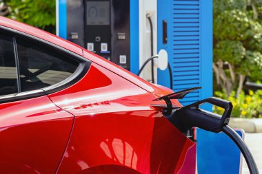 Elektrikli arabaları şarj ederken kablolu EV 'yi kabloya bağlamak. Yeşil enerji ve ekolojik güç kavramında elektrikli araba şarj istasyonu. Teknoloji elektrikli araç kavramı