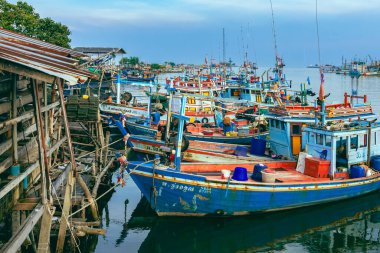 PHETCHABURI-THAILAND, Ekim 23, 2022: Akşam Phoo Chuk Köprüsü 'nde deniz manzaralı çeşitli renkli balıkçı teknelerinin güzel manzarası. Balıkçı tekneleri balıkçı köyüne yanaştı.