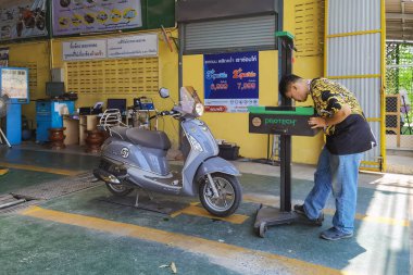 KANCHANABURI, THAILAND-MAYIS 23,2023: Araç denetim tesisinde yıllık araç vergisi ödemeleri için araç denetim sertimine motosiklet denetimi. Atölyedeki motosikletin durumunu kontrol eder.