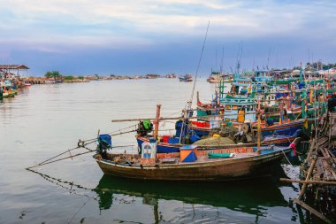 PHETCHABURI-THAILAND, Ekim 23, 2022: Akşam Phoo Chuk Köprüsü 'nde deniz manzaralı çeşitli renkli balıkçı teknelerinin güzel manzarası. Balıkçı tekneleri balıkçı köyüne yanaştı.